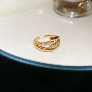 Close-up of golden vintage geometric ring with zircon stones in a white velvet box