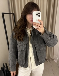 Detail of grey herringbone jacket with classic collar and large utility chest pockets