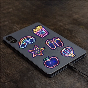 Holographic neon stickers with popcorn and star designs on a dark tablet case