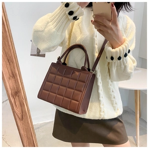 Brown quilted square handbag shown in mirror selfie for size and styling reference