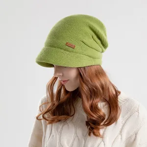 Winter gebreide muts in grasgroen met rand en leren label voor warmte en stijl