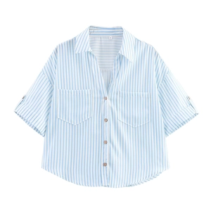 Détail de chemise en lin rayée bleue avec poches poitrine et boutons en bois naturel