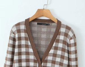 Detailed macro view of checkered knit cardigan collar with V-neck ribbing and size S label