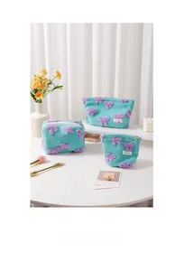 Three-piece teddy plush makeup bag set with purple bows and blue fuzzy fabric detail