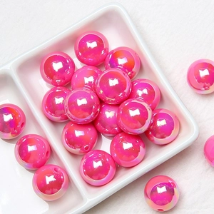 Close-up of pink iridescent acrylic beads for DIY jewelry in a ceramic dish