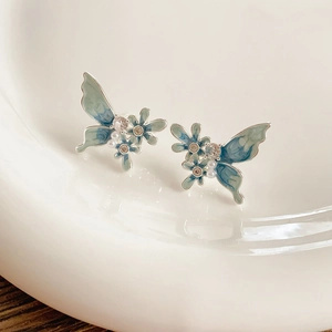 Détails des boucles d'oreilles papillon bleues avec perles et motifs floraux en émail