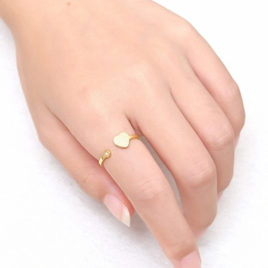 Detailed macro view of an 18K gold open ring featuring a matte heart and a tiny crystal