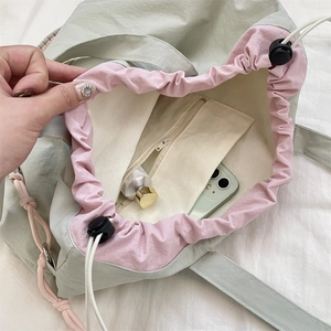Detail der grünen Nylon-Tasche mit Innenfutter, Reißverschlussfach und Kordelzugverschluss