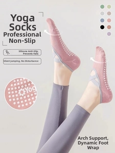 Detailed view of pink yoga socks with cross elastic straps and white anti-slip silicone dots