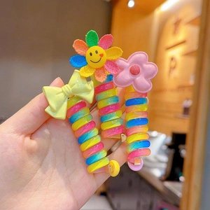 Close-up of colorful spiral hair ties with cute bow and flower charms for kids