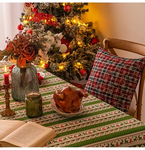Detail of red and green striped Christmas tablecloth with reindeer and tree patterns