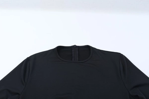 Detail of round neckline and hidden back zipper on a black long-sleeve jumpsuit