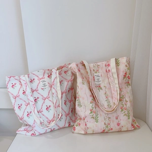 Detail of floral cotton canvas tote bags with ribbon prints and woven handles