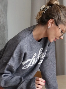 Gray jacquard knit sweater with letter patterns and chic leopard hair clip in lifestyle shot