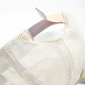 Vue macro du tissu en maille respirante et de la sangle Velcro réglable sur la casquette bébé