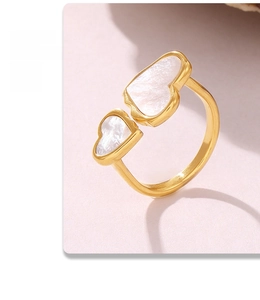 Macro shot of gold heart ring with white mother of pearl inlay and sweet quote