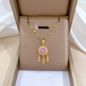 Titanium dreamcatcher necklace with pink gem and feather charms in a jewelry box