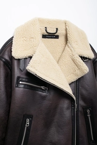 Detailed close-up of the plush faux shearling lining and vintage brown leather texture
