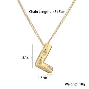 Dettaglio del ciondolo lettera L dorata con zirconi e dimensioni 2,1x1,5 cm