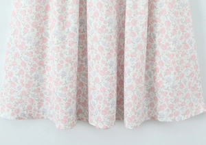 Dettaglio del tessuto in chiffon floreale con pieghe morbide e stampa di fiori rosa