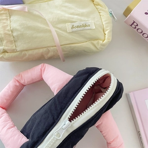 Detail of colorful canvas stationery pouch with pink padded handle and zipper closure