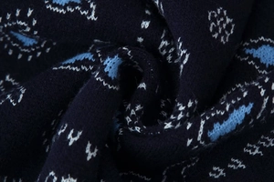 Close-up of dark blue knit fabric with light blue and white geometric jacquard pattern