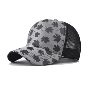 Detail view of plaid maple leaf trucker hat with breathable black mesh and curved brim