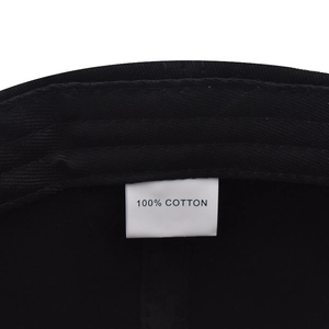 Detailed view of the 100% cotton material tag inside the black baseball cap