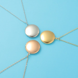 Three round mirror-polished stainless steel lockets in silver, gold, and rose gold finishes