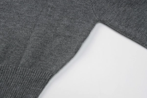 Gros plan détaillé sur la texture en maille fine et la couture plate de ce haut gris foncé