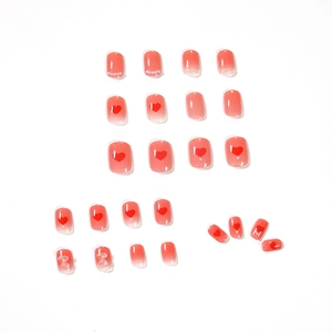Pink gradient press-on nails with 3D bear charms, hearts and pearls on white backdrop