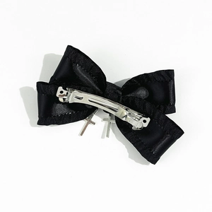 Detail of Gothic black bow hair clip with silver metal cross pendants and back spring clip