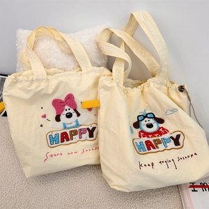 Detail of cute puppy embroidery and canvas texture on beige drawstring tote bag