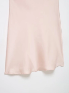 Détail montrant la texture en soie lisse et la couture de l'ourlet de la robe satinée rose