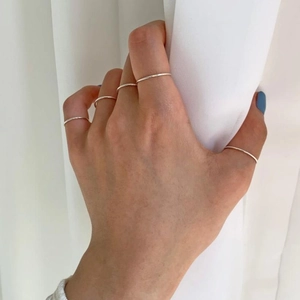Set of five minimalist S925 sterling silver thin band rings worn on a hand
