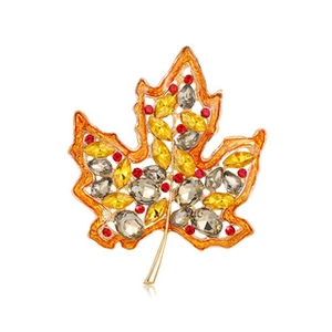 Detail of maple leaf brooch with orange and yellow crystals in gold-toned setting