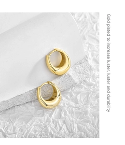 Detail of gold plated hoop earrings showing thick crescent design and polished luster
