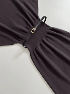Detail of knit midi dress waist featuring vertical ribbing and a black belt with gold buckle