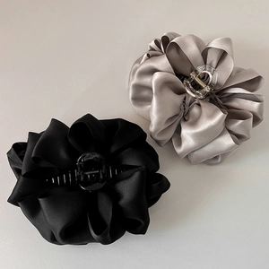 Detailed view of large black and silver-grey satin fabric bow claw hair clips