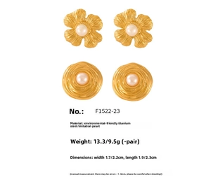 Detail of vintage gold plated steel floral and spiral earrings with pearl inlay