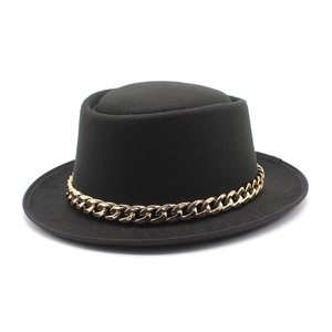 Elegant black wool boater hat with a bold gold chain band detail on a white background