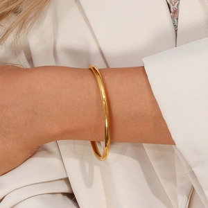 Minimalist 18K gold plated stainless steel open bangle on woman's wrist