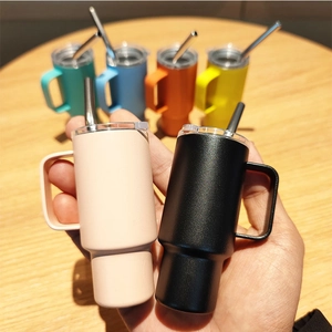 Close-up of mini 2oz stainless steel tumblers with handles and straws in multiple colors