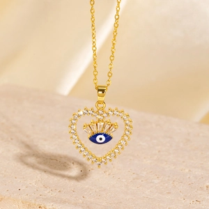 Macro view of gold heart necklace with blue evil eye inlay and sparkling crystals
