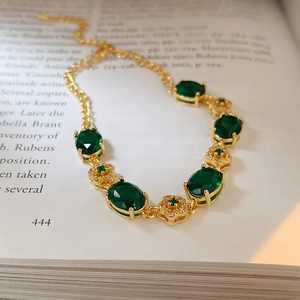 Vintage emerald flower bracelet with gold plating and cubic zirconia on a book page
