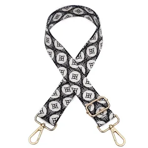Adjustable woven replacement bag strap with black and white geometric patterns and gold buckles