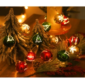 Macro shot of LED Christmas globes with snowflakes and Merry Christmas text on cedar