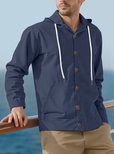 Detail view of navy blue cotton linen hooded shirt with wood buttons on a cruise deck