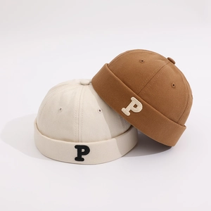 Detail of retro P letter embroidery on beige and caramel brown docker hats