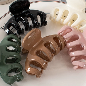 Minimalist glossy hair claws in five colors displayed on a ceramic white plate